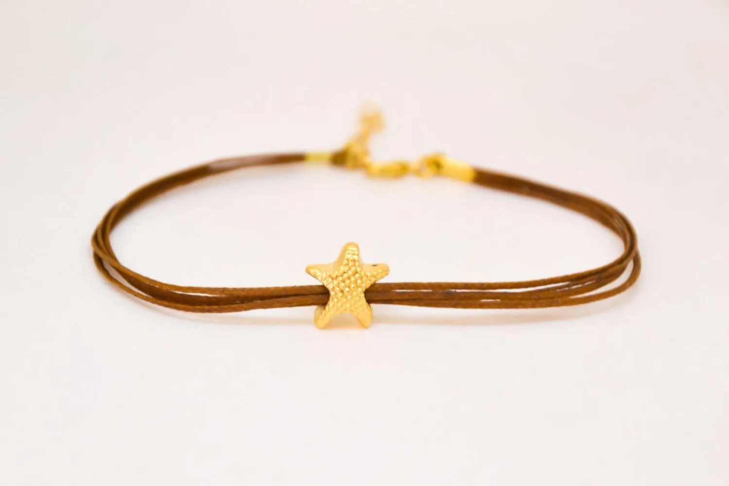 Ankle bracelet with gold plated starfish charm, brown string