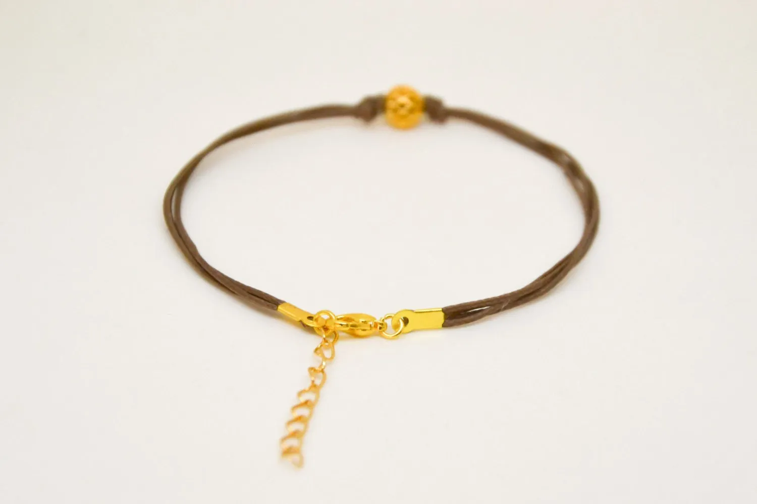 Brown ankle bracelet with matt gold ball bead charm