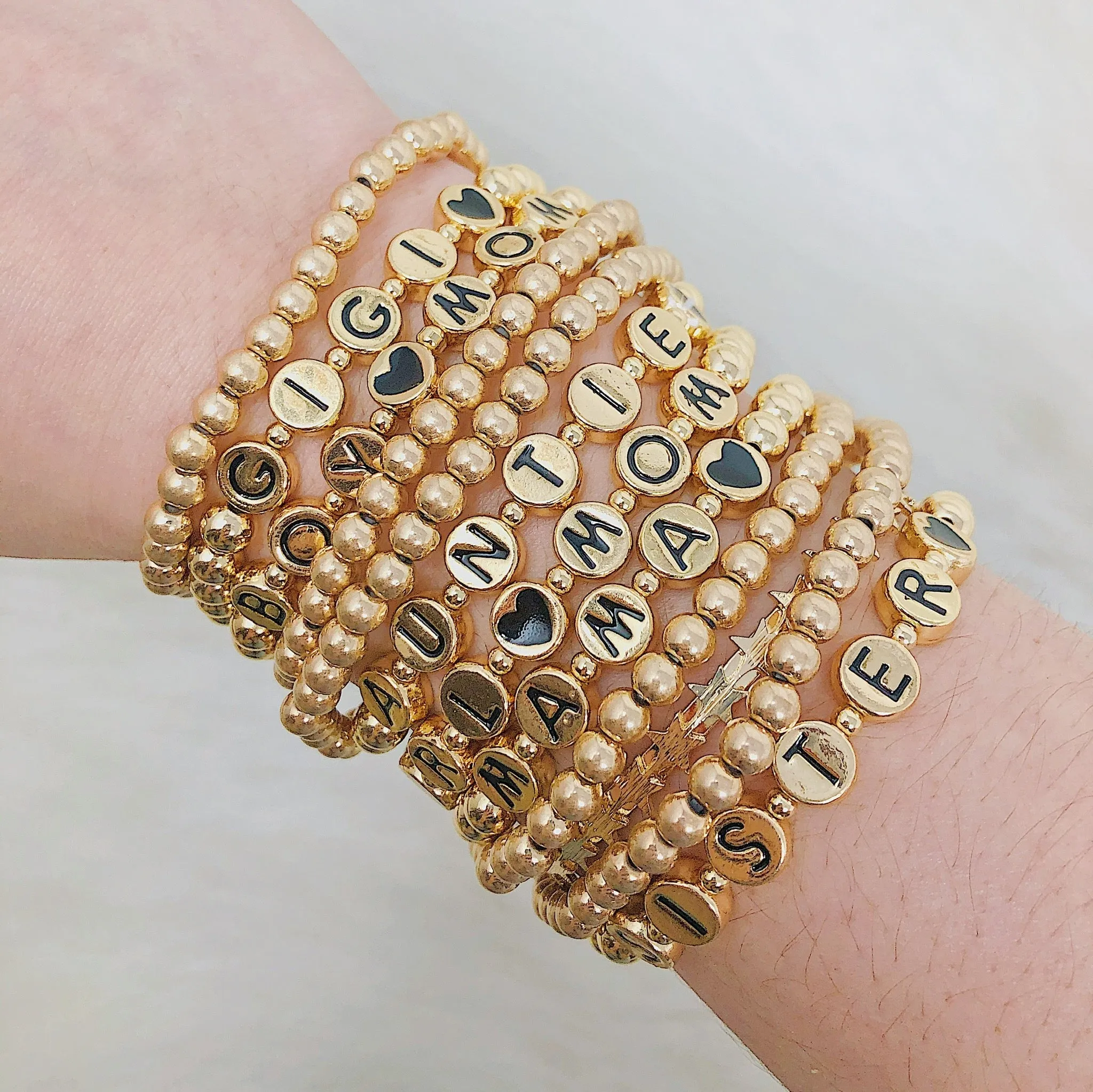 Gold Tone Ball Bead Bracelet With Black Stamped Letter Beads