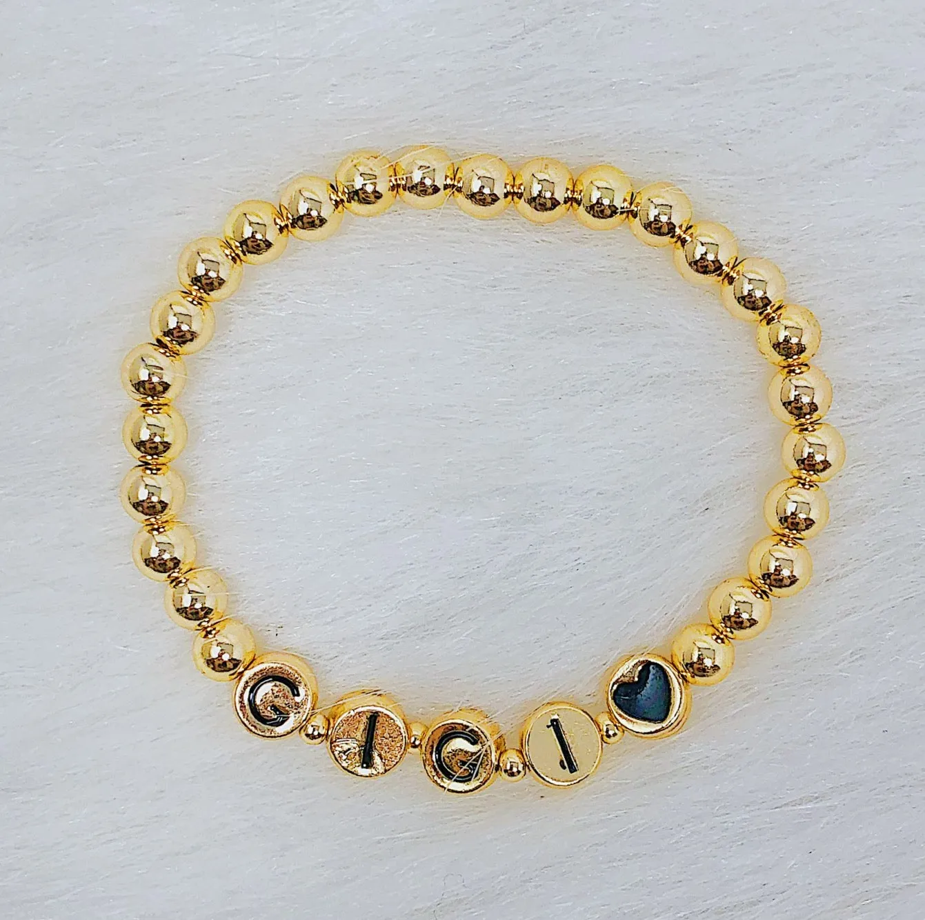 Gold Tone Ball Bead Bracelet With Black Stamped Letter Beads