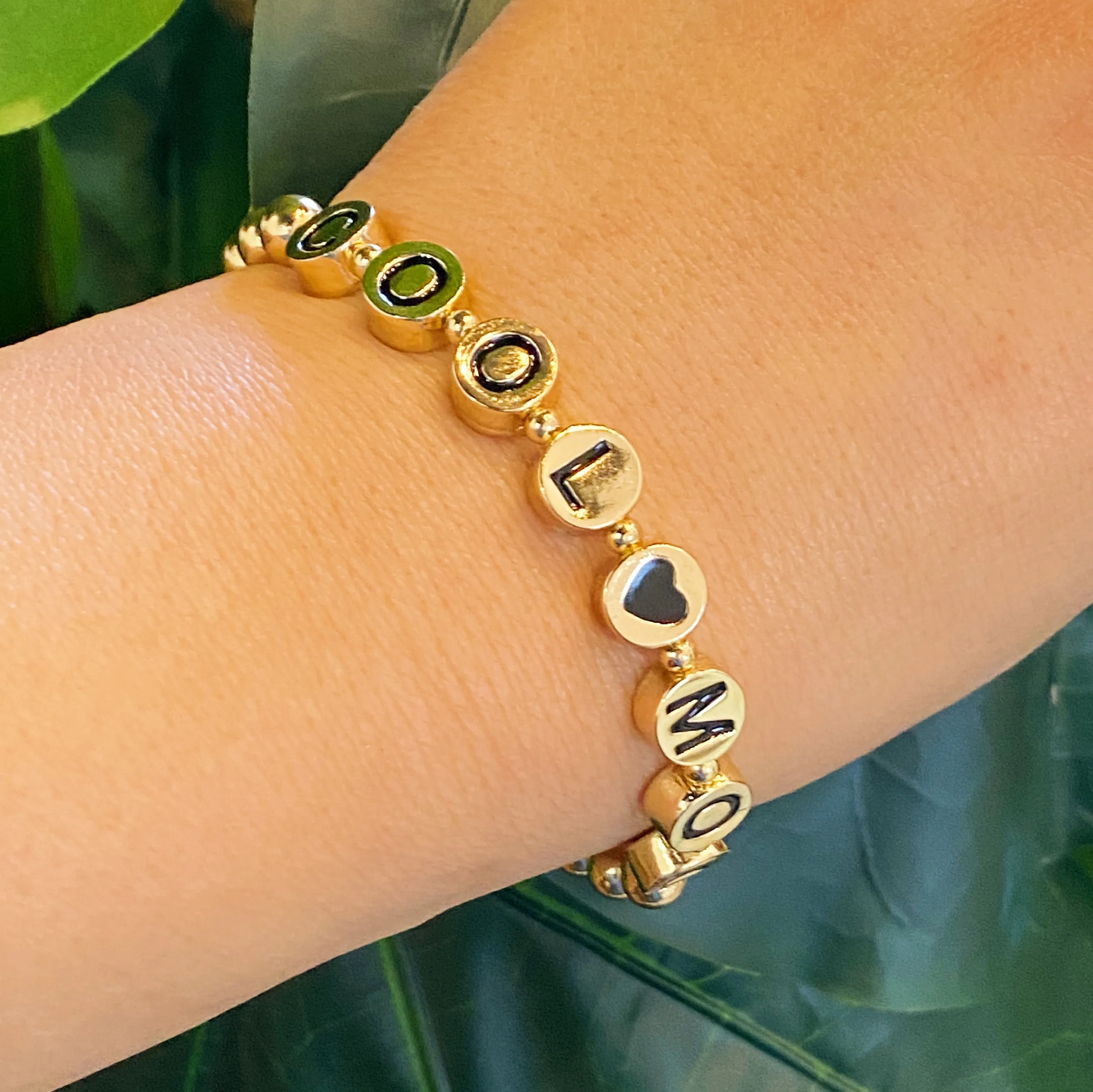 Gold Tone Ball Bead Bracelet With Black Stamped Letter Beads